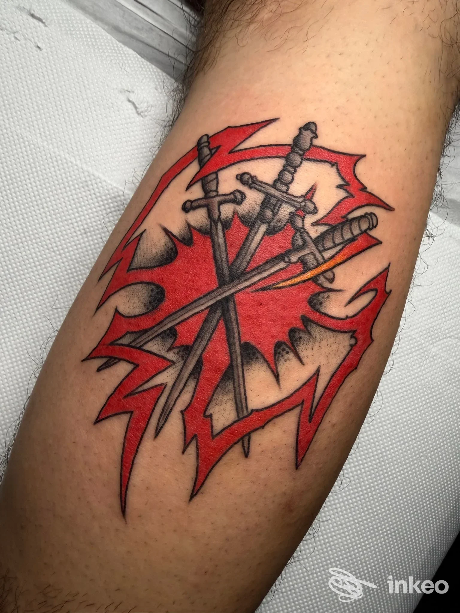 Tatuaggio di tre spade incrociate su sfondo rosso sul polpaccio, Cry Later Tattoo Shop, Corato.