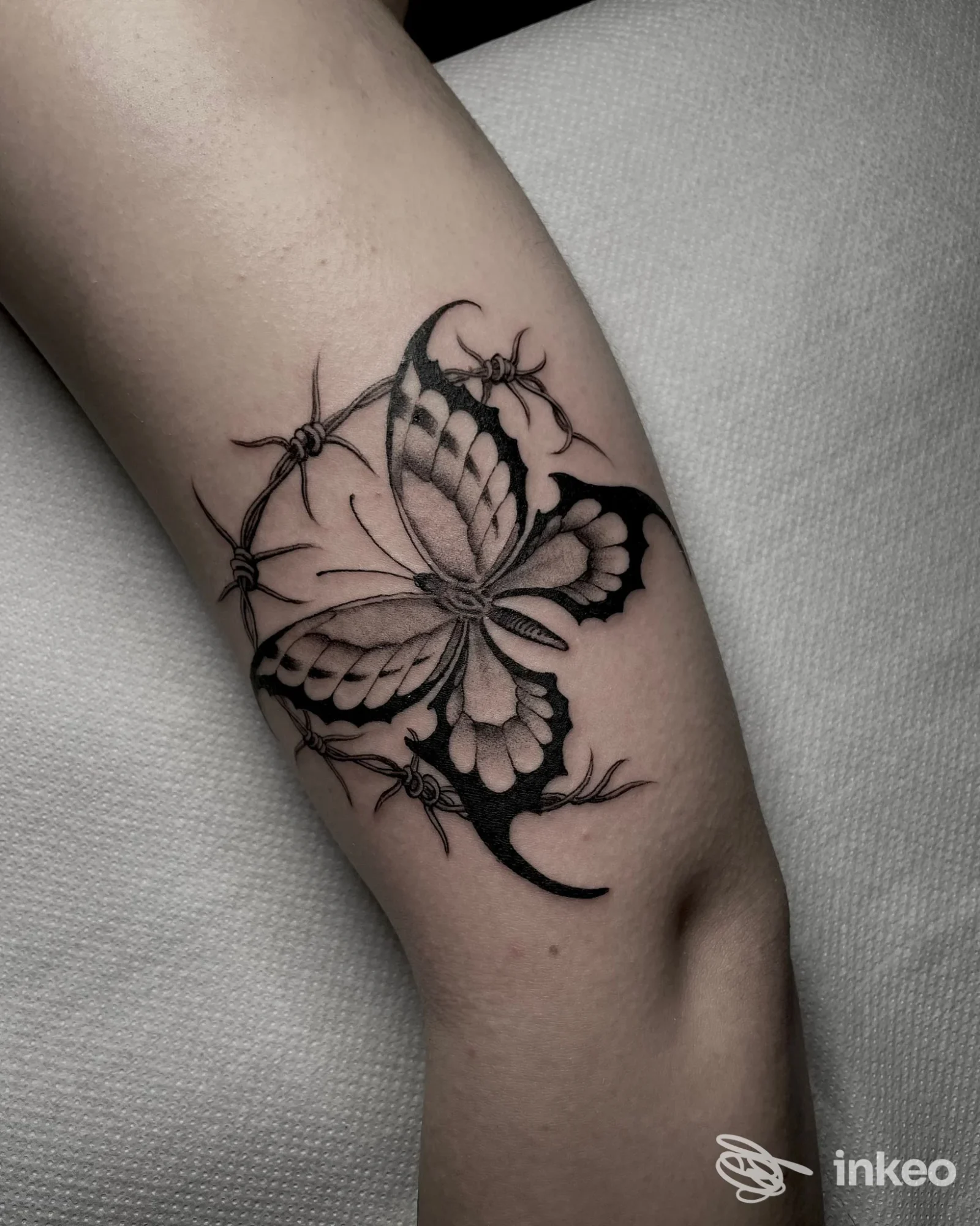 Tatuaggio a farfalla in nero con dettagli ornamentali sull'avambraccio interno, realizzato da Cry Later Tattoo Shop a Corato.