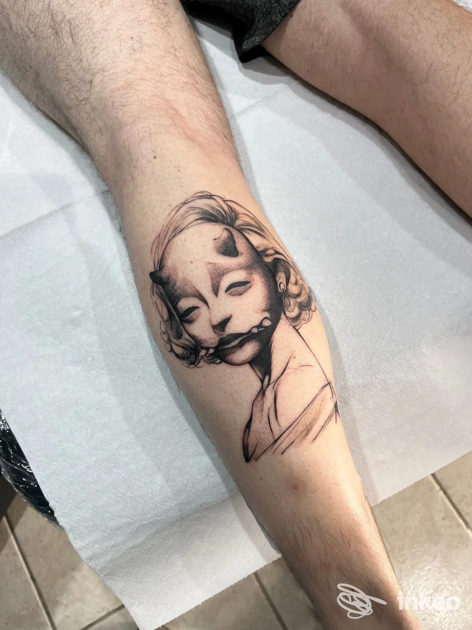 Tatuaggio in bianco e nero di un volto stilizzato sul polpaccio, Tattoon Studio, Bitonto.