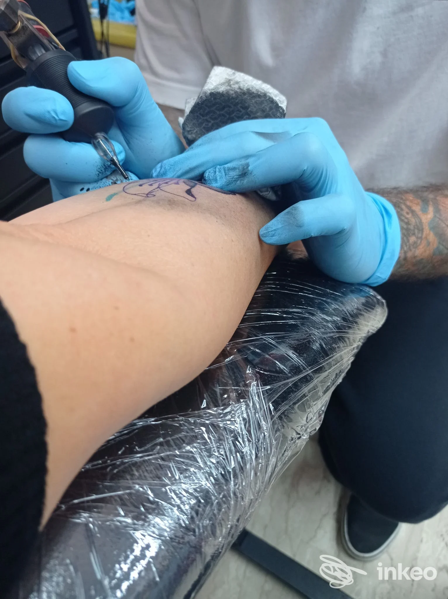 Artista di Gioko's Tattoo Shop a Barletta che esegue un tatuaggio sul lato interno dell'avambraccio di un cliente, primo piano della procedura.