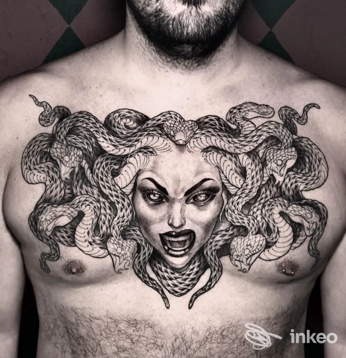 Grande tatuaggio a tema volto con serpenti sul petto, foto inviata da Furious Ink ad Aosta.