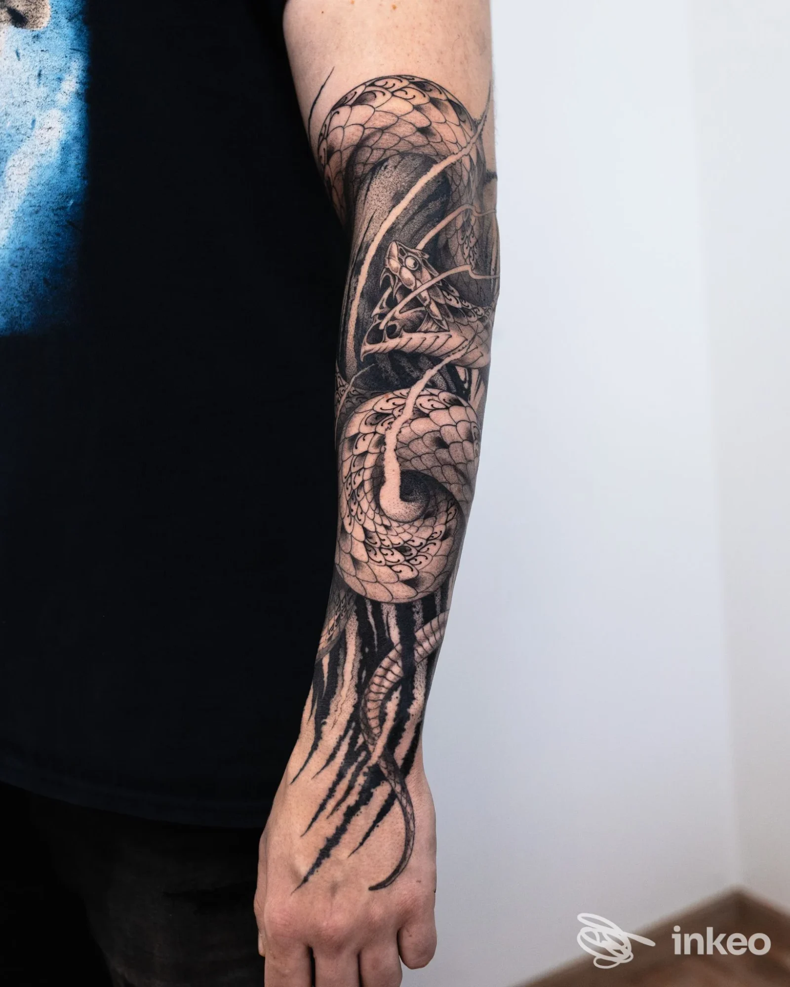 Tatuaggio a manica con un serpente in bianco e nero sull'avambraccio, foto fornita da Happy Ink Parlor a Merano.