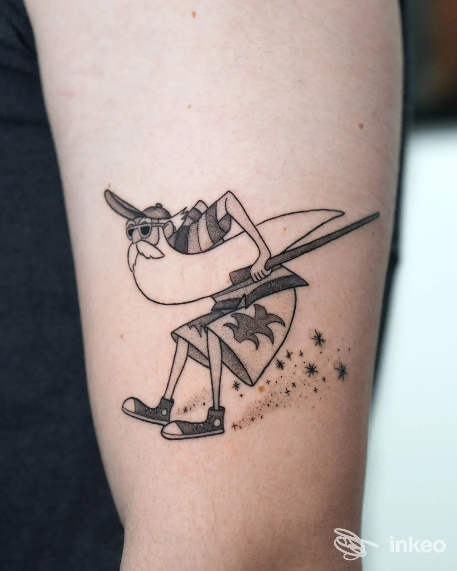 Tatuaggio blackwork/linework su avambraccio: personaggio cartoon con occhiali e stelle, foto dallo studio Happy Ink Parlor a Merano.