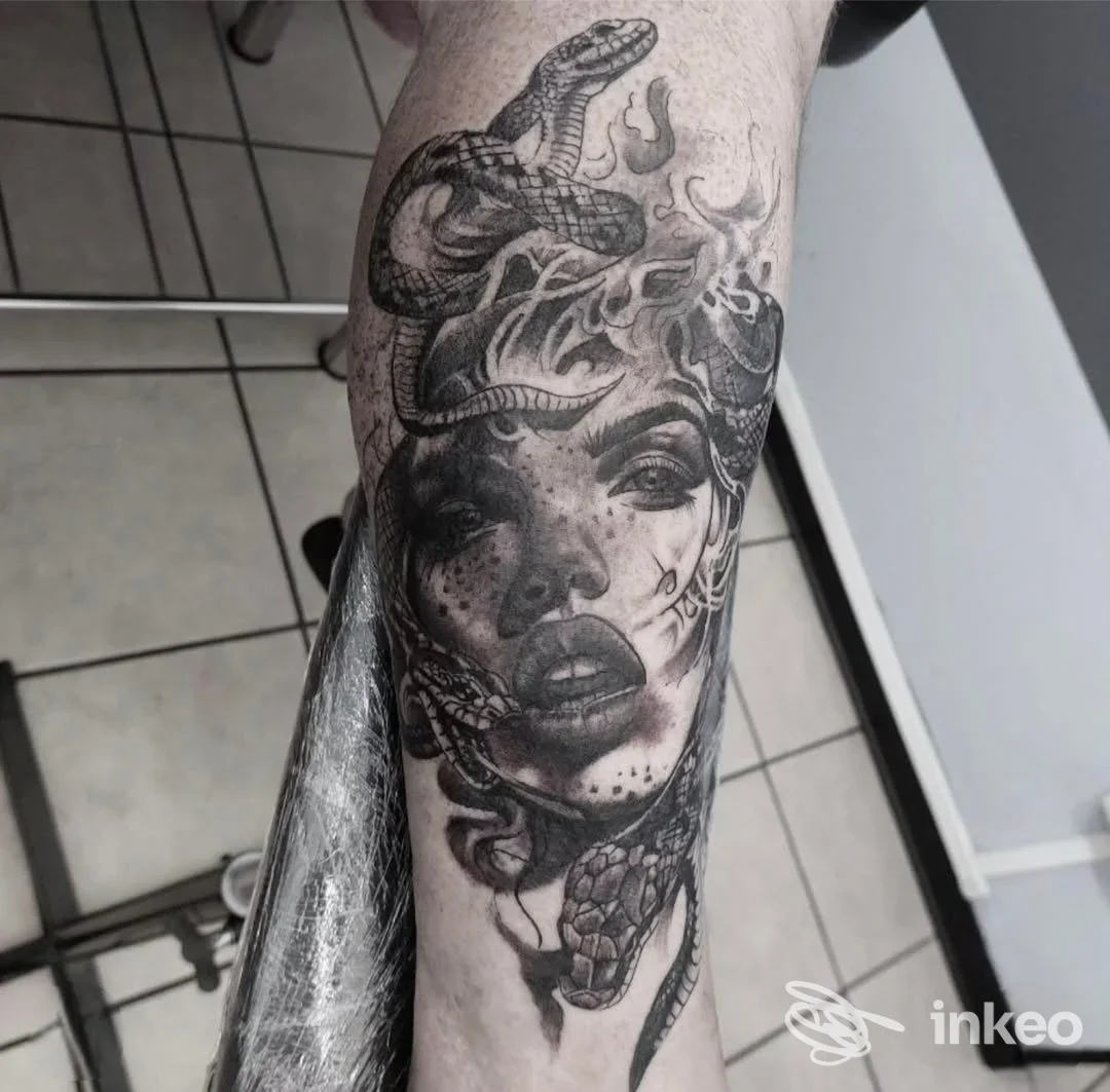 Tatuaggio in bianco e nero sul antebraccio raffigurante volto femminile avvolto da serpenti. Jam Ink Tattoo Family, Ferrara.