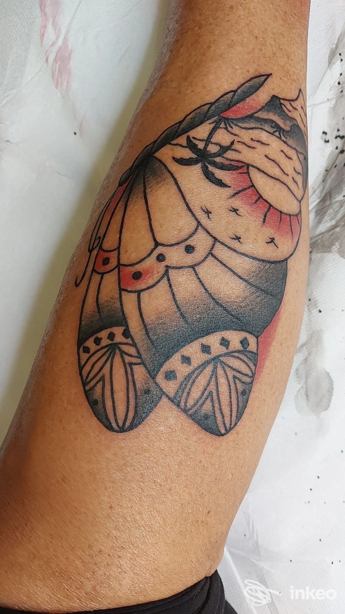 Tatuaggio con linee nere, ombreggiature e aree rosse sull'avambraccio, eseguito da Dark Old Tattoo a Roma.