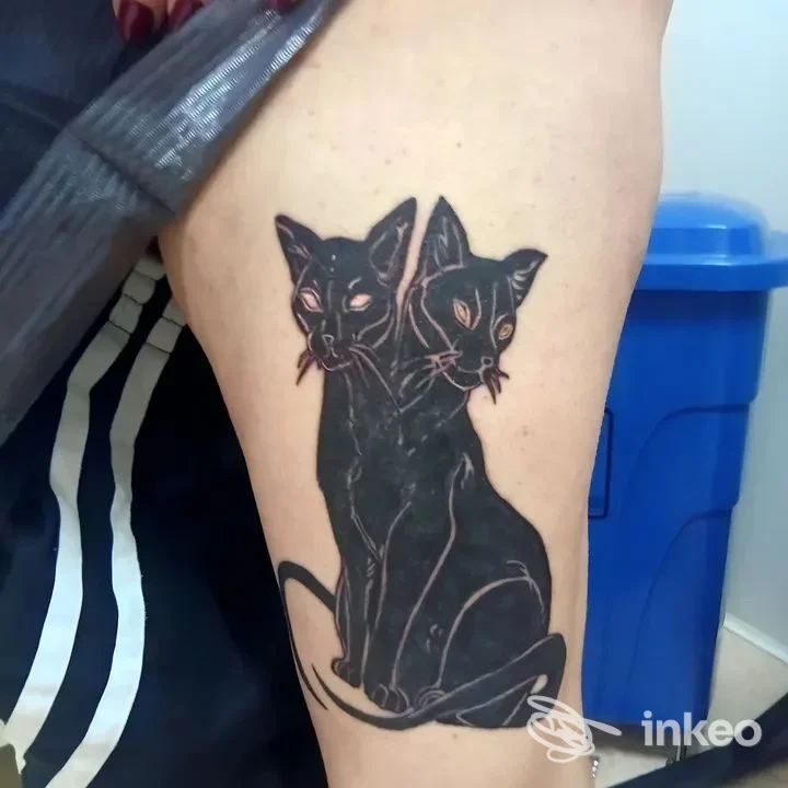 Tatuaggio su coscia con due gatti neri stilizzati, foto inviata da Ale Tattoo a Valenzano.