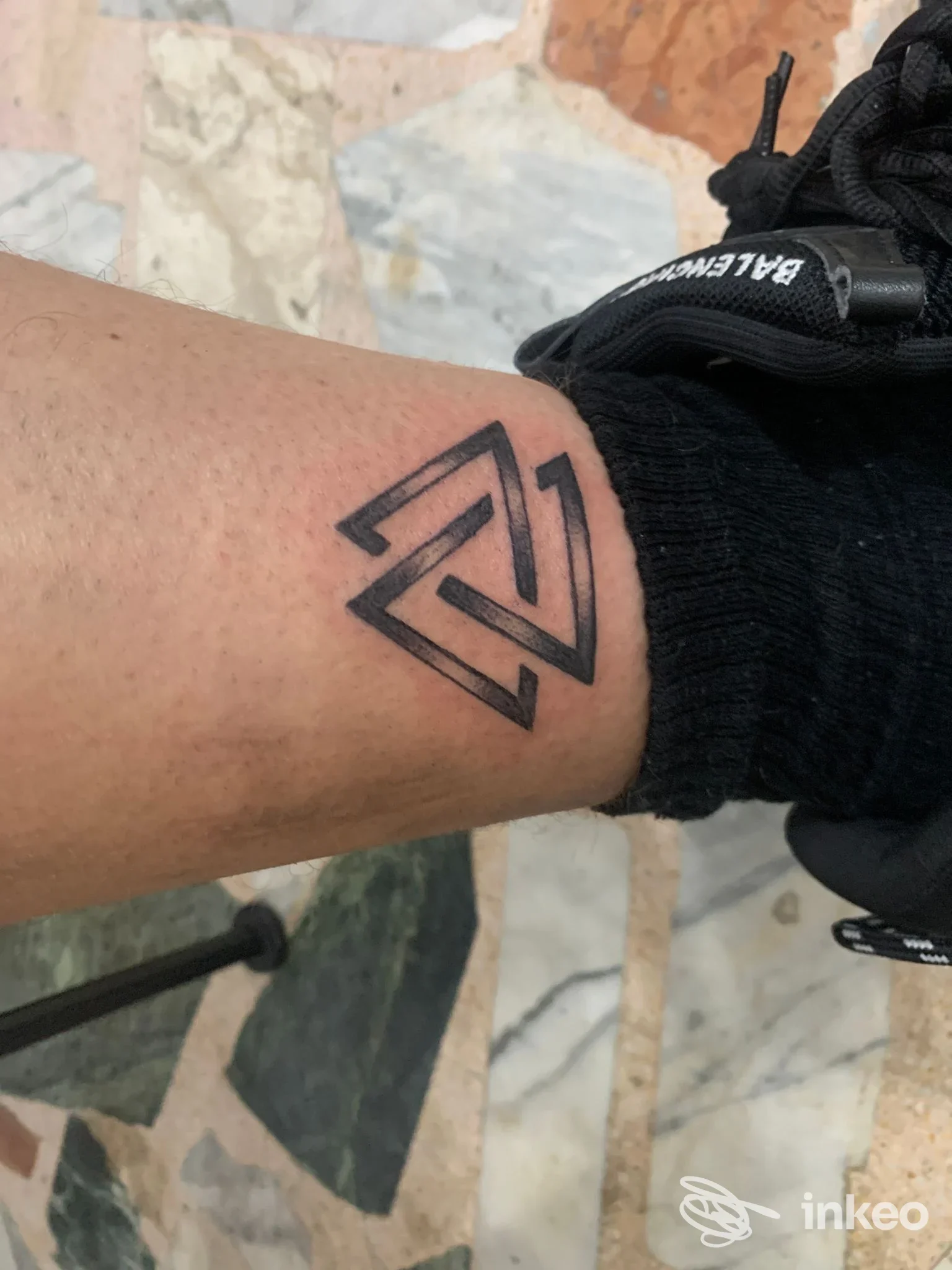 Tatuaggio geometrico nero sopra la caviglia, fotografato in primo piano; realizzato da Witch's Ink Roma a Roma.