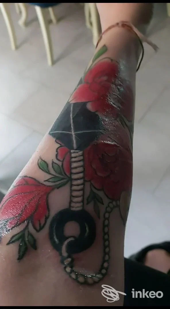 Tatuaggio floreale e catena sull'avambraccio, fotografia di Witch's Ink Roma - Tatuaggi & Piercing a Roma.
