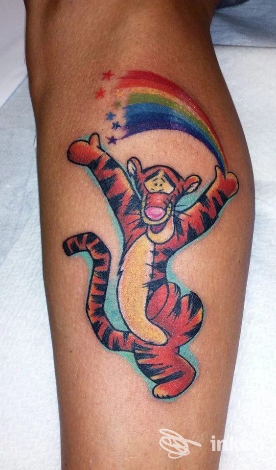 Tatuaggio colorato di Tigro con arcobaleno sul polpaccio, realizzato da Ink&Ele a Ghislarengo.