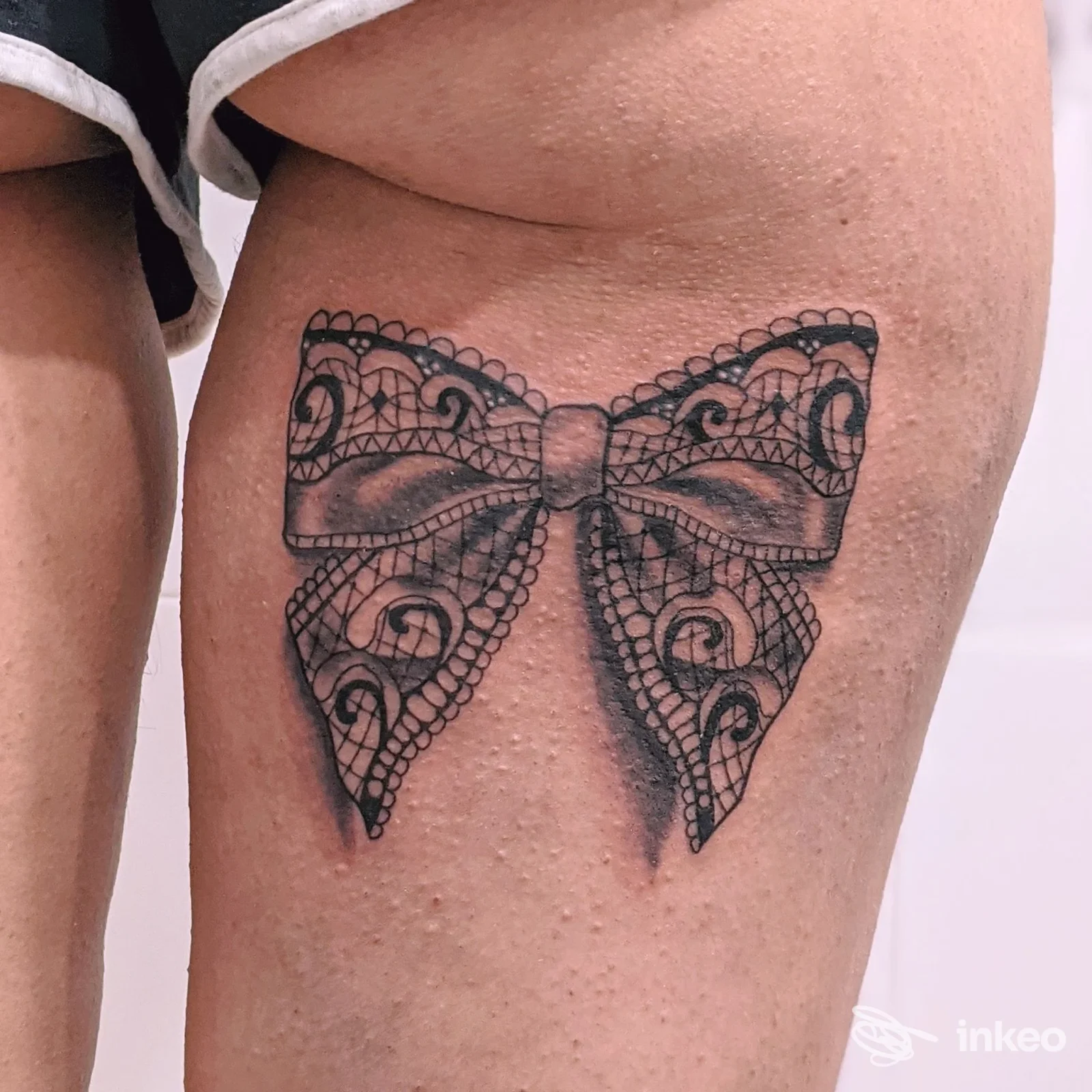 Tatuaggio a forma di fiocco in stile pizzo sul lato della coscia, foto fornita da Danjotattoo a Isola del Liri.