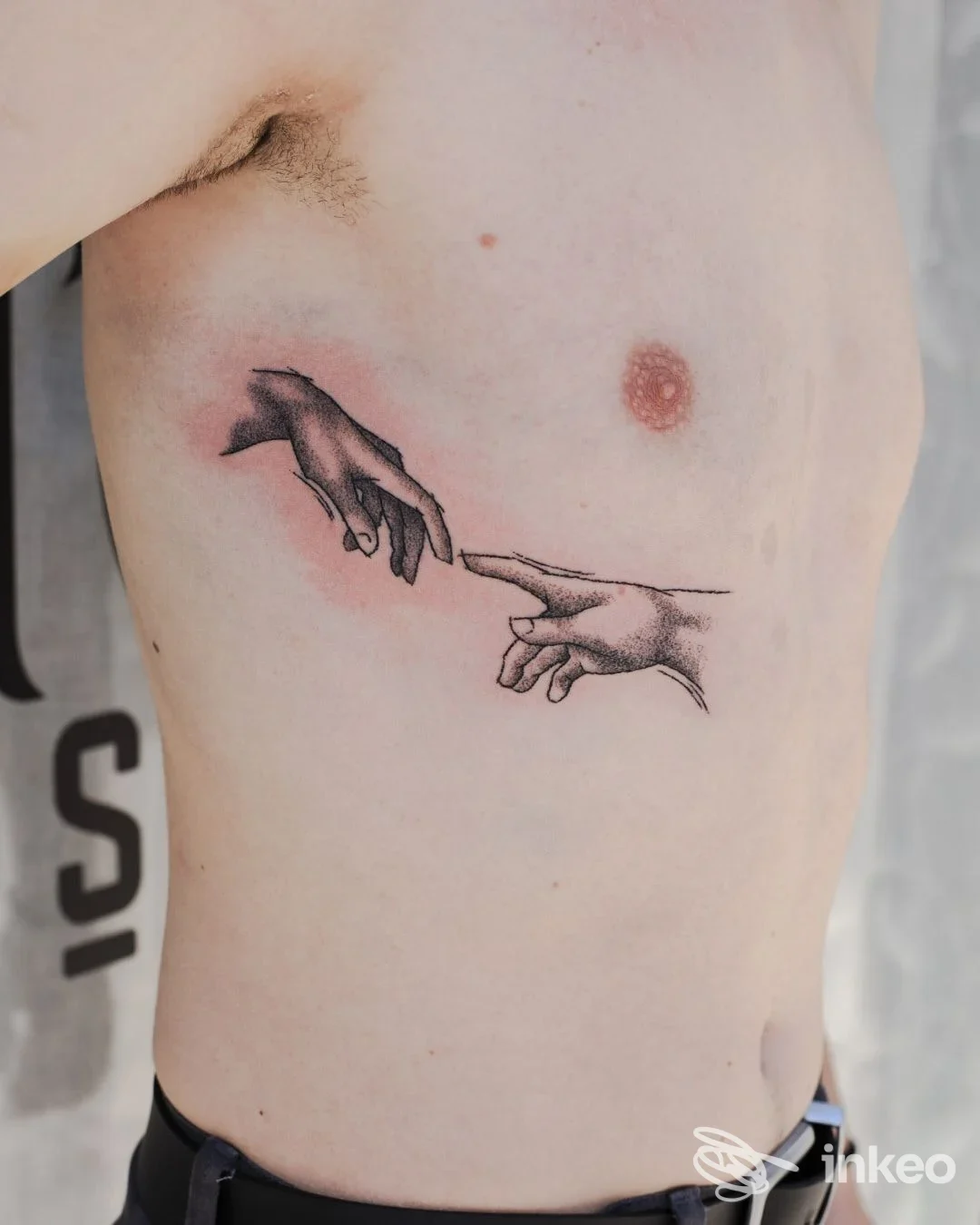 Tatuaggio di due mani su fianco sinistro, foto fornita da Distort Tattoo House a Tortona.