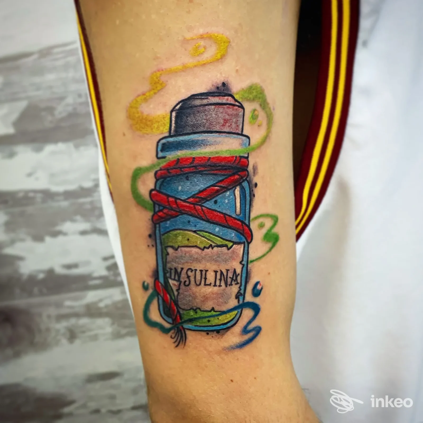 Tatuaggio avambraccio: bomboletta spray colorata con nastri rossi e fumi verdi/gialli, foto fornita da 2wayink tattoostudio a Nepi.