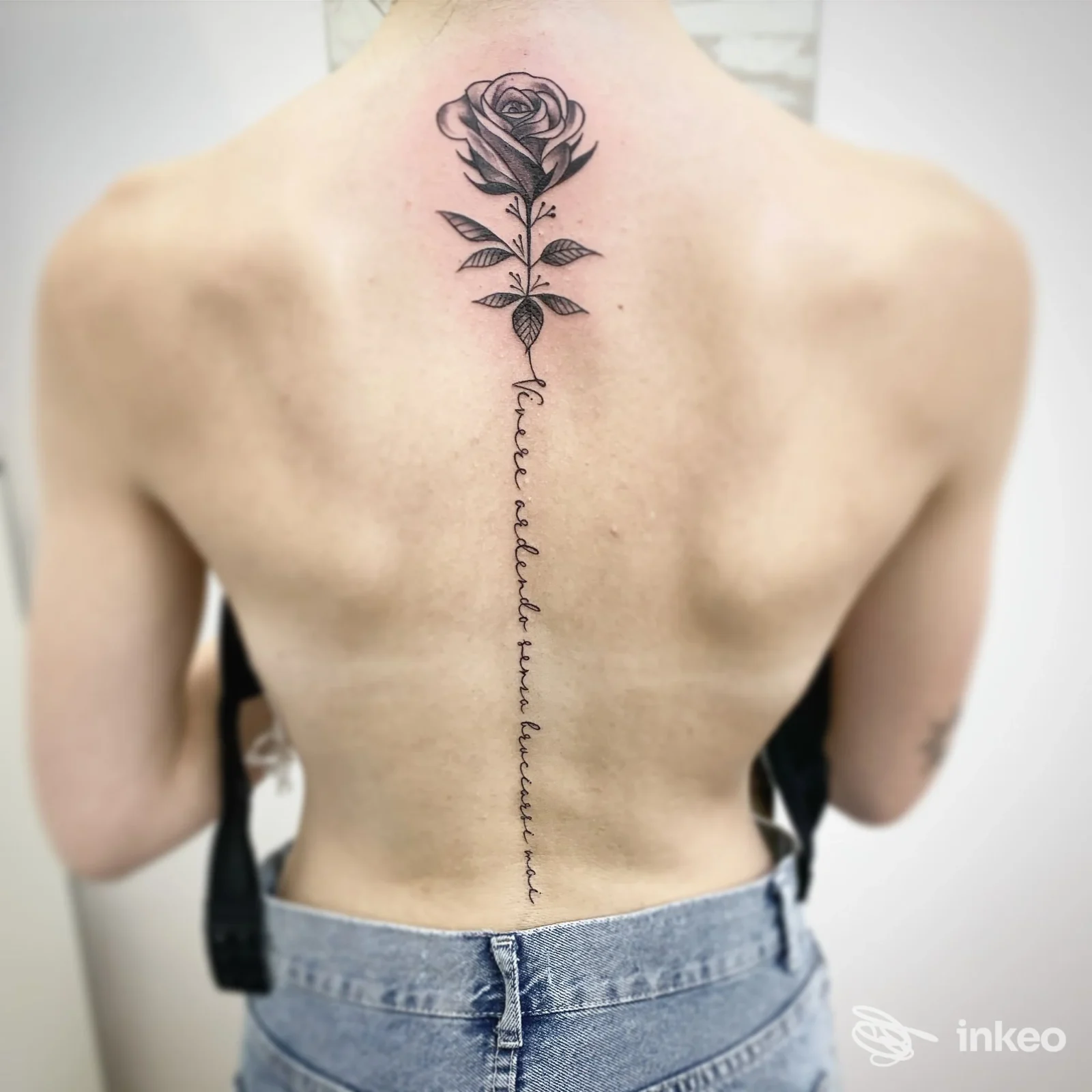 Tatuaggio sulla colonna dorsale con rosa nera e scritta in corsivo, foto scattata nello studio 2wayink tattoostudio a Nepi.