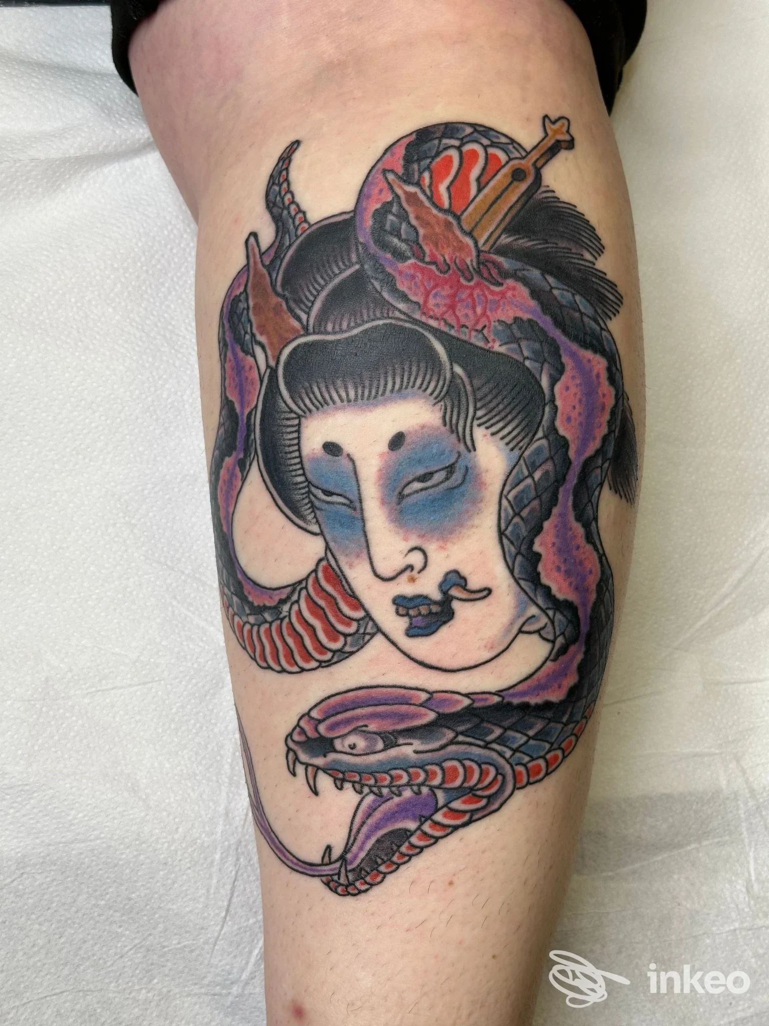 Tatuaggio sul polpaccio raffigurante volto femminile stilizzato avvolto da un serpente, foto di Country life tattoo studio a Rieti.