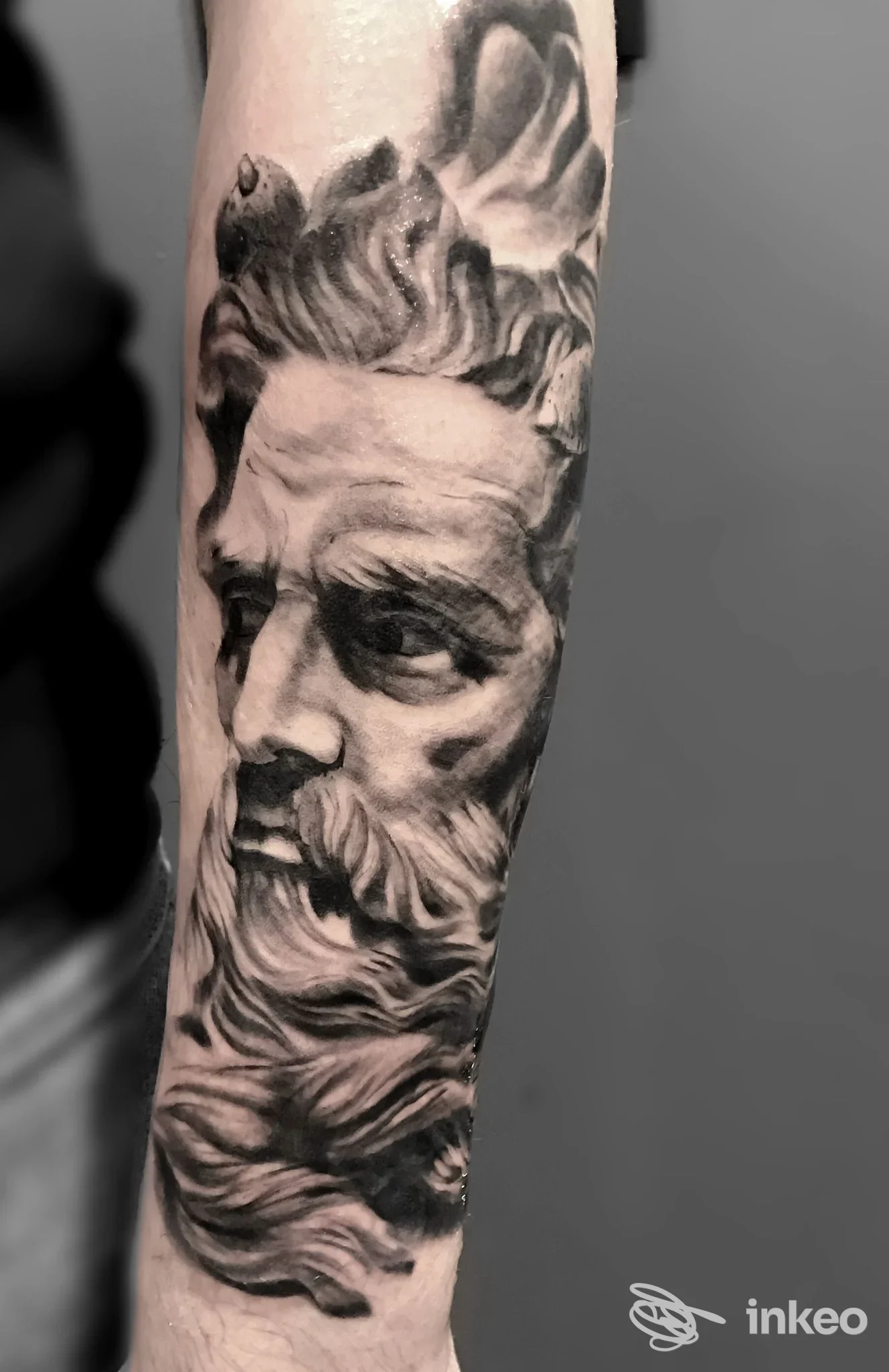 Tatuaggio realistico in bianco e nero di un volto classico sull'avambraccio, Blackbird Tattoo Studio, Prato.