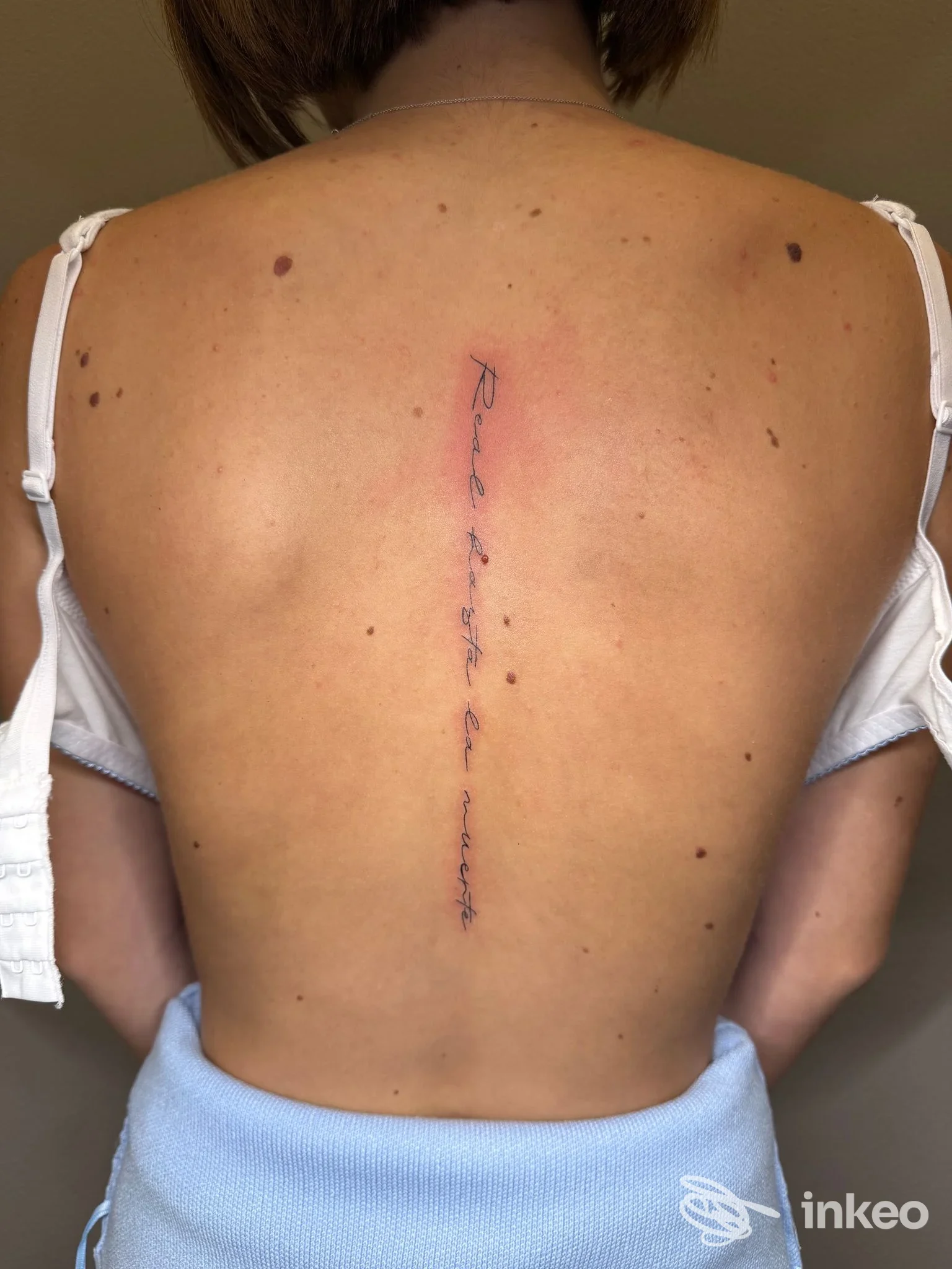Tatuaggio testuale verticale sulla colonna vertebrale di una persona; foto condivisa dallo studio Verdiana Mora Studio Tattoo a Borgomanero.