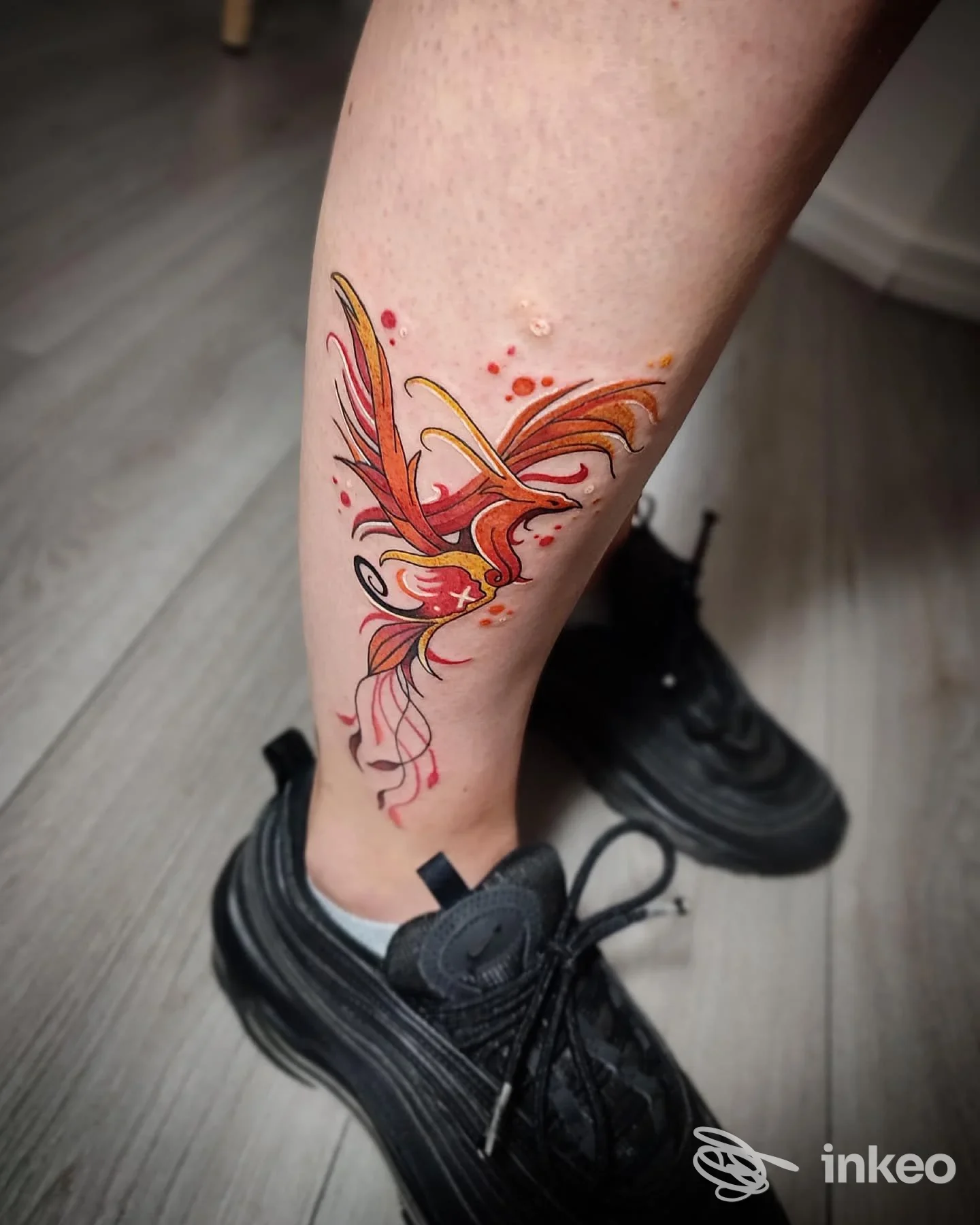 Tatuaggio colorato a forma di uccello sul polpaccio, foto inviata da Arona Ink, Arona.