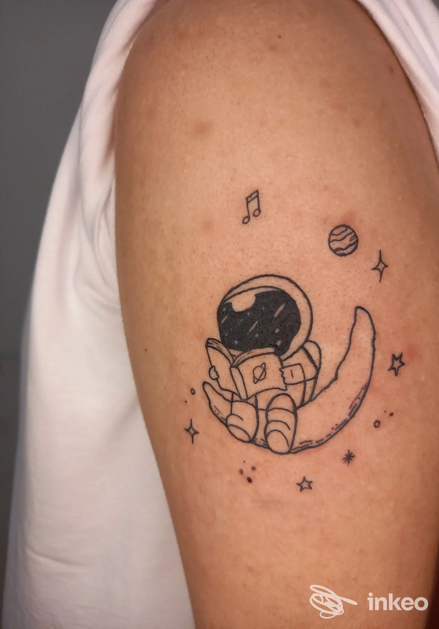Tatuaggio di un astronauta su mezzaluna sul braccio superiore, Tattoo & Dreams, Prato.