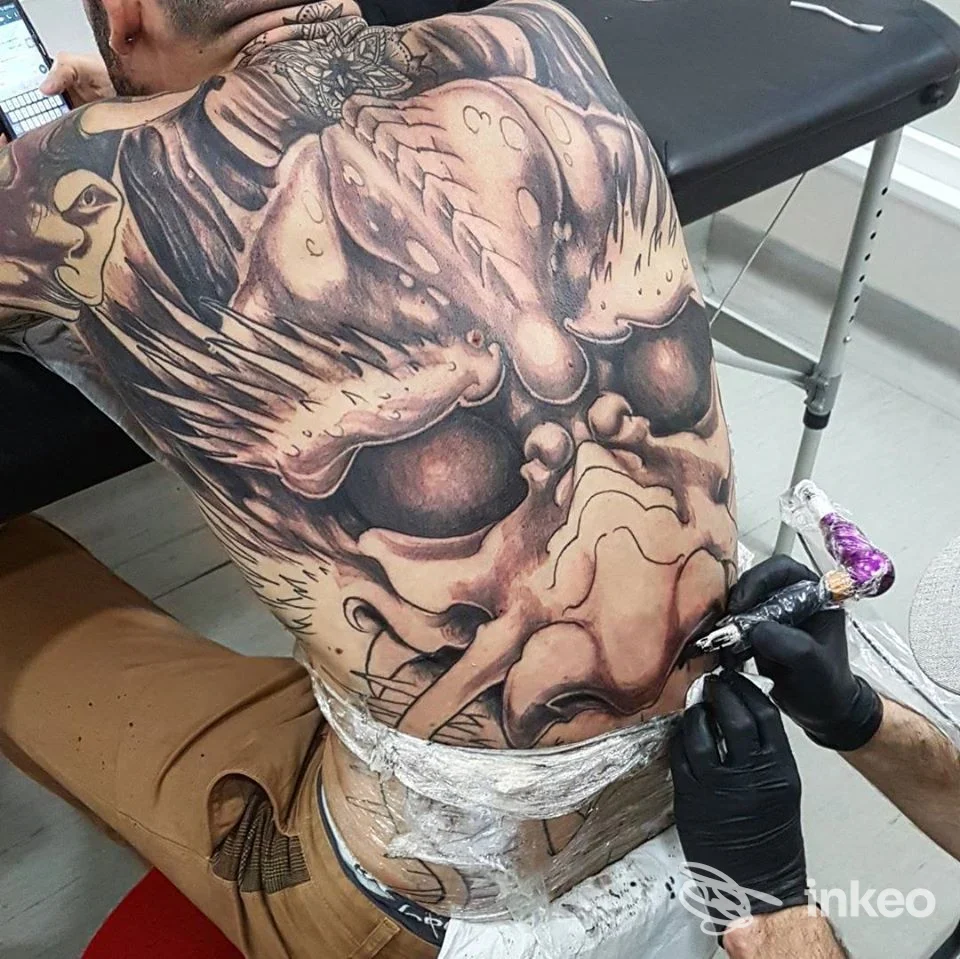 Tatuaggio backpiece in lavorazione nello studio RAM TATTOO a Tivoli, tatuatore al lavoro sulla schiena del cliente.