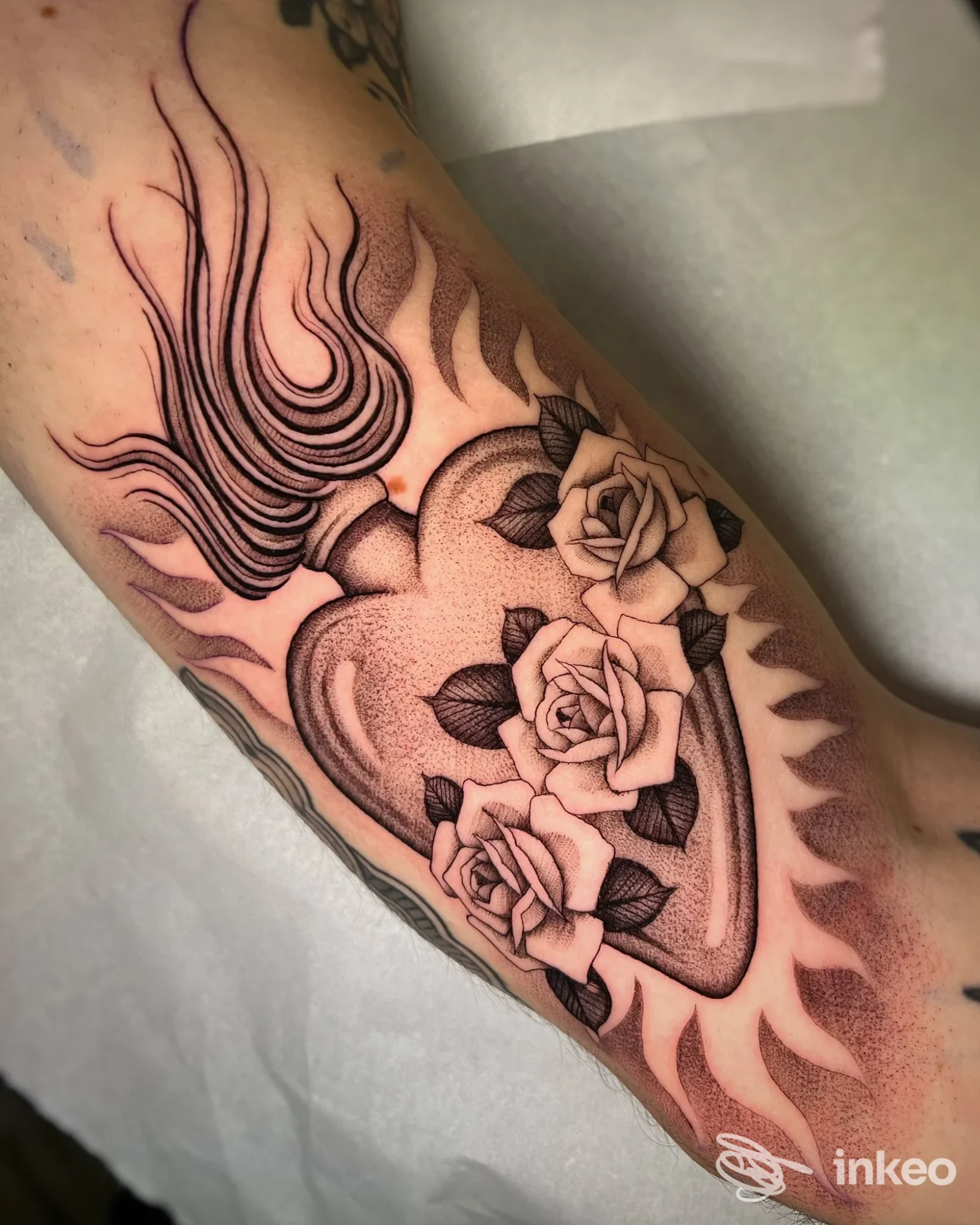 Tatuaggio a cuore con fiamme e rose su avambraccio, foto fornita da Black Ornament Tattoo Studio, Capranica.