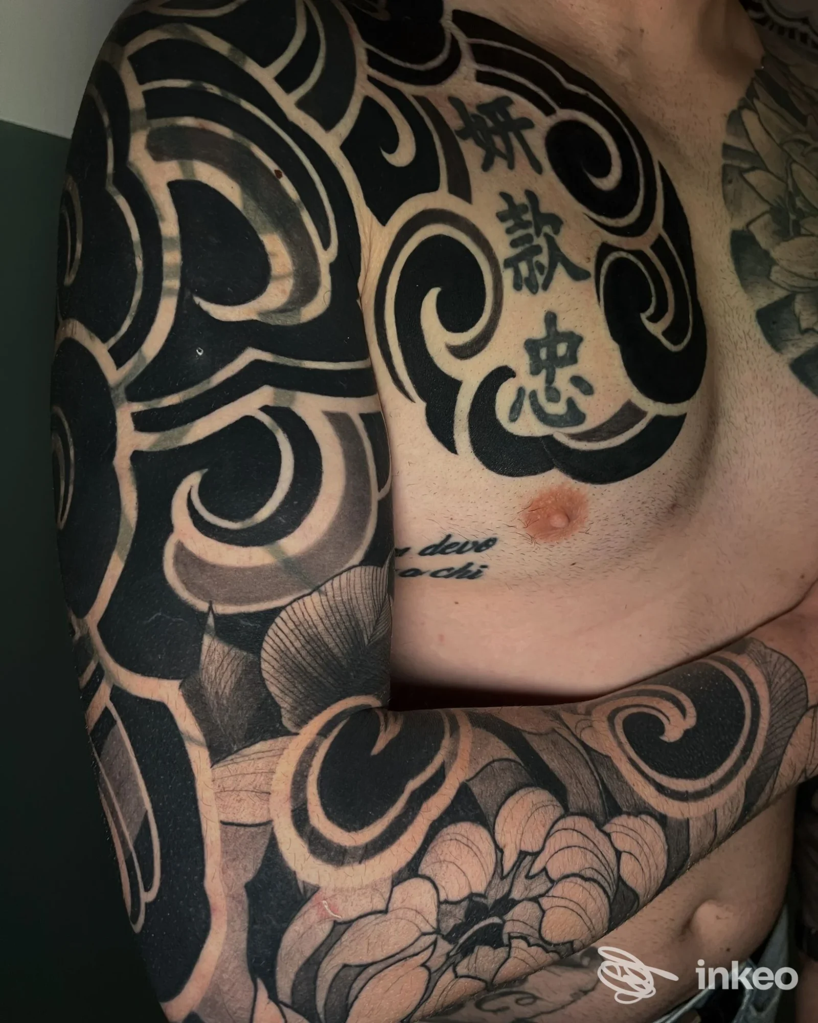 Ampia composizione blackwork su torace e braccio in fotografia dello studio Black Ornament Tattoo Studio, Capranica.