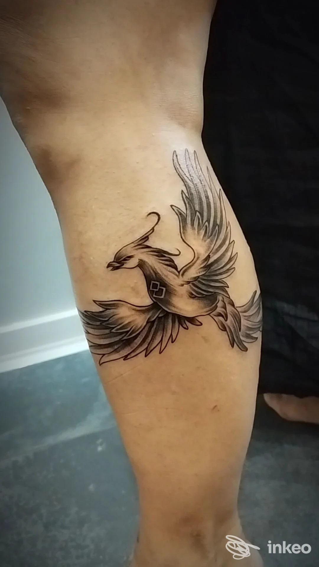 Tatuaggio a inchiostro nero e grigio di un uccello sul polpaccio, Alma Gitana Tattoo Studio, Terracina.
