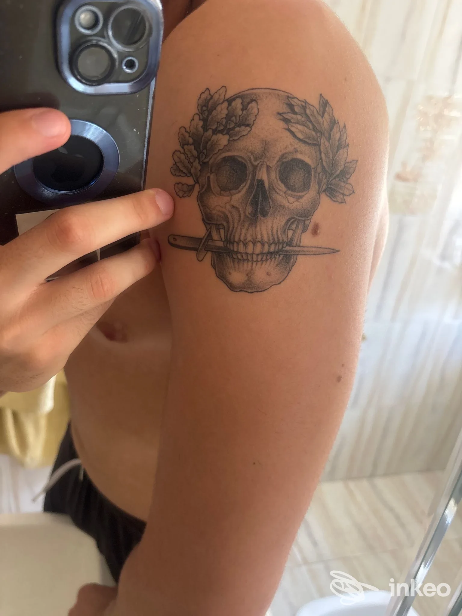Fotografia del tatuaggio su spalla di un teschio con alloro e pugnale — Alma Gitana Tattoo Studio, Terracina.