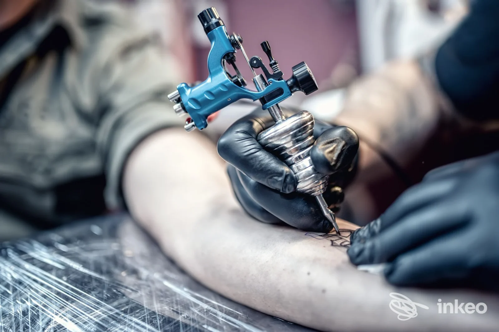Primo piano di tatuaggio sull'avambraccio eseguito da Bad Apple Ink a Tito, artista al lavoro con macchinetta e guanti neri.