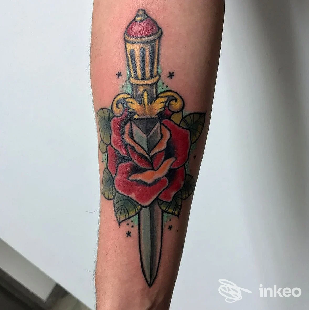 Tatuaggio tradizionale di pugnale e rosa sull'avambraccio, realizzato da Pagan Tattoo Art Studio a Latina.