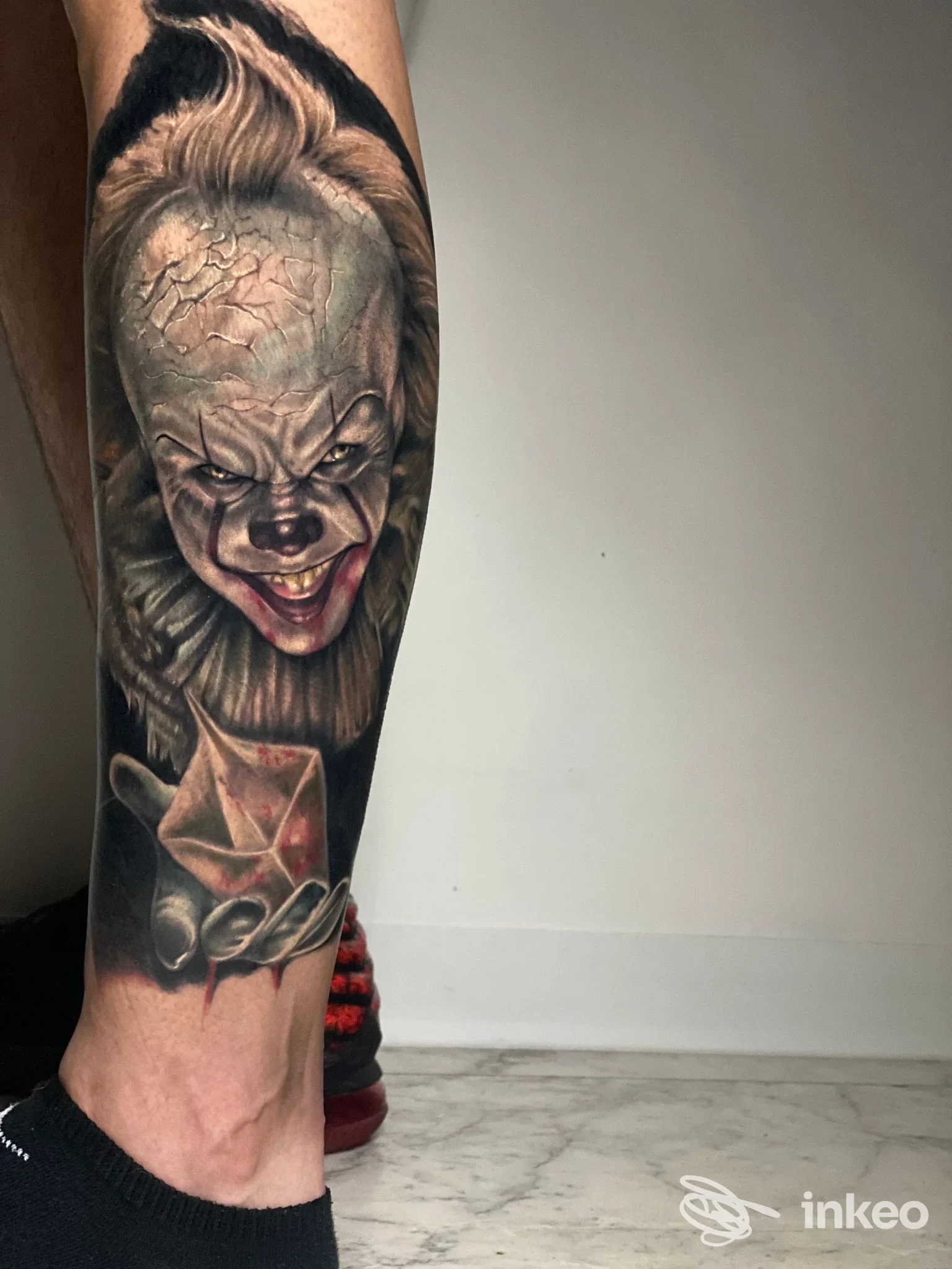 Tatuaggio realistico su polpaccio con volto grottesco e mano, Black Beard Tattoo, Sora.