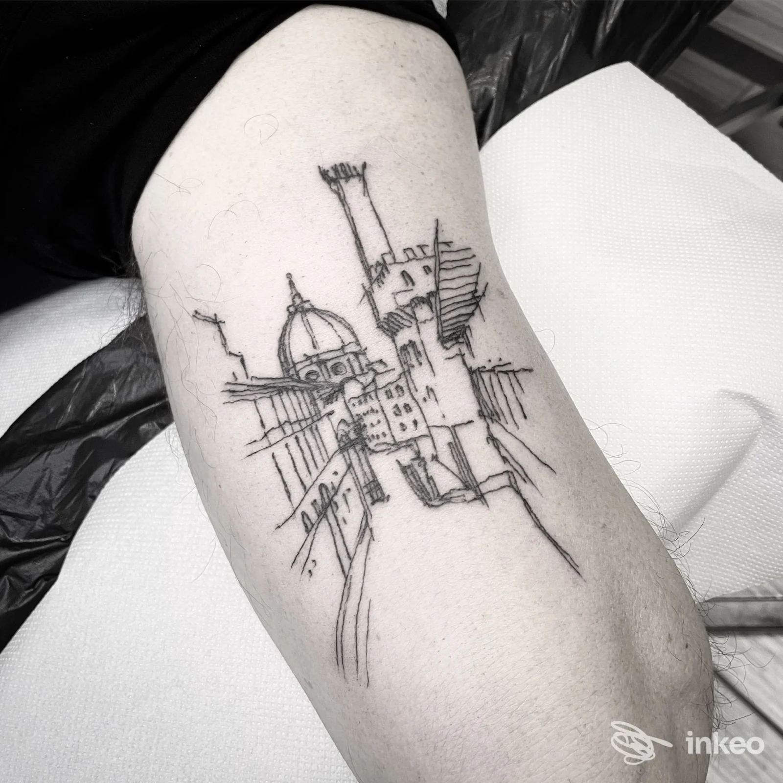 Tatuaggio linework urbano sul braccio, foto dallo studio ENKRE a Livorno che mostra il dettaglio del tratto nero su pelle.