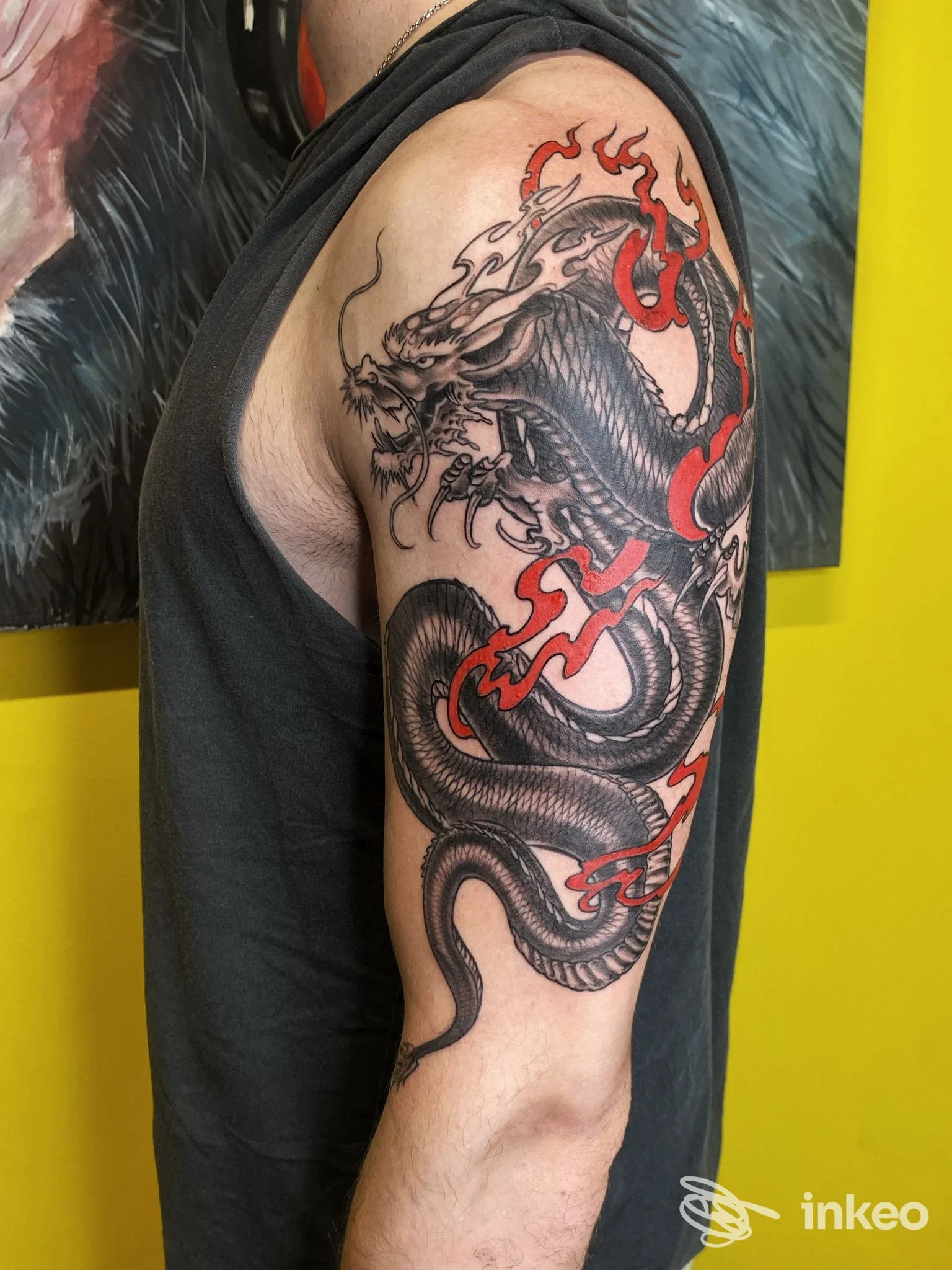 Foto di un grande tatuaggio a forma di drago sul braccio e spalla, realizzato da Planet052 a Treviso.