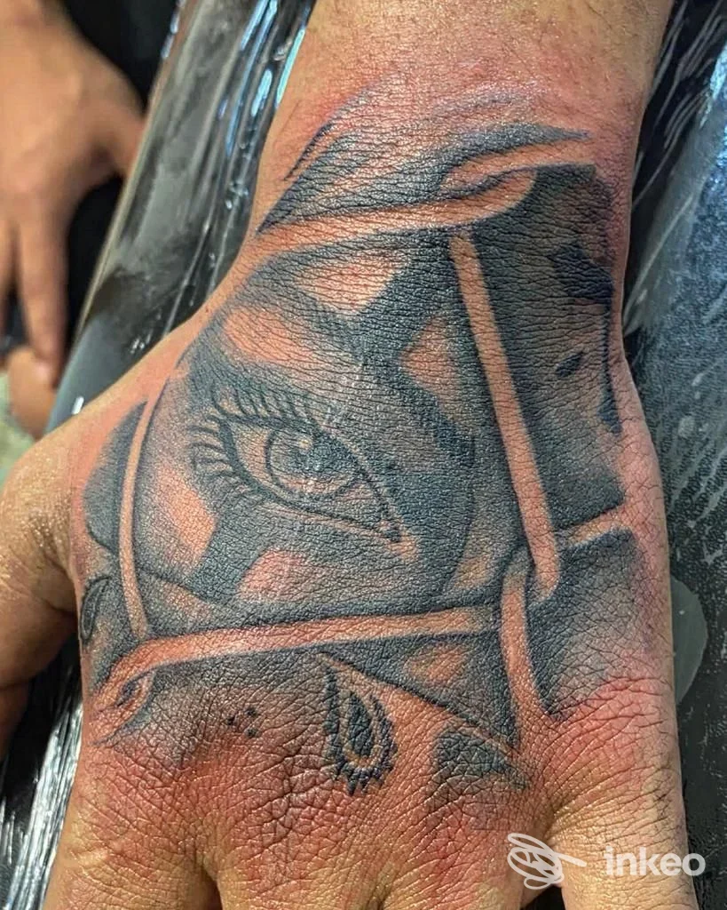 Tatuaggio black & grey con occhio stilizzato sul dorso della mano, eseguito da Devil Dog Tattoo a Cremona, pelle ancora arrossata.