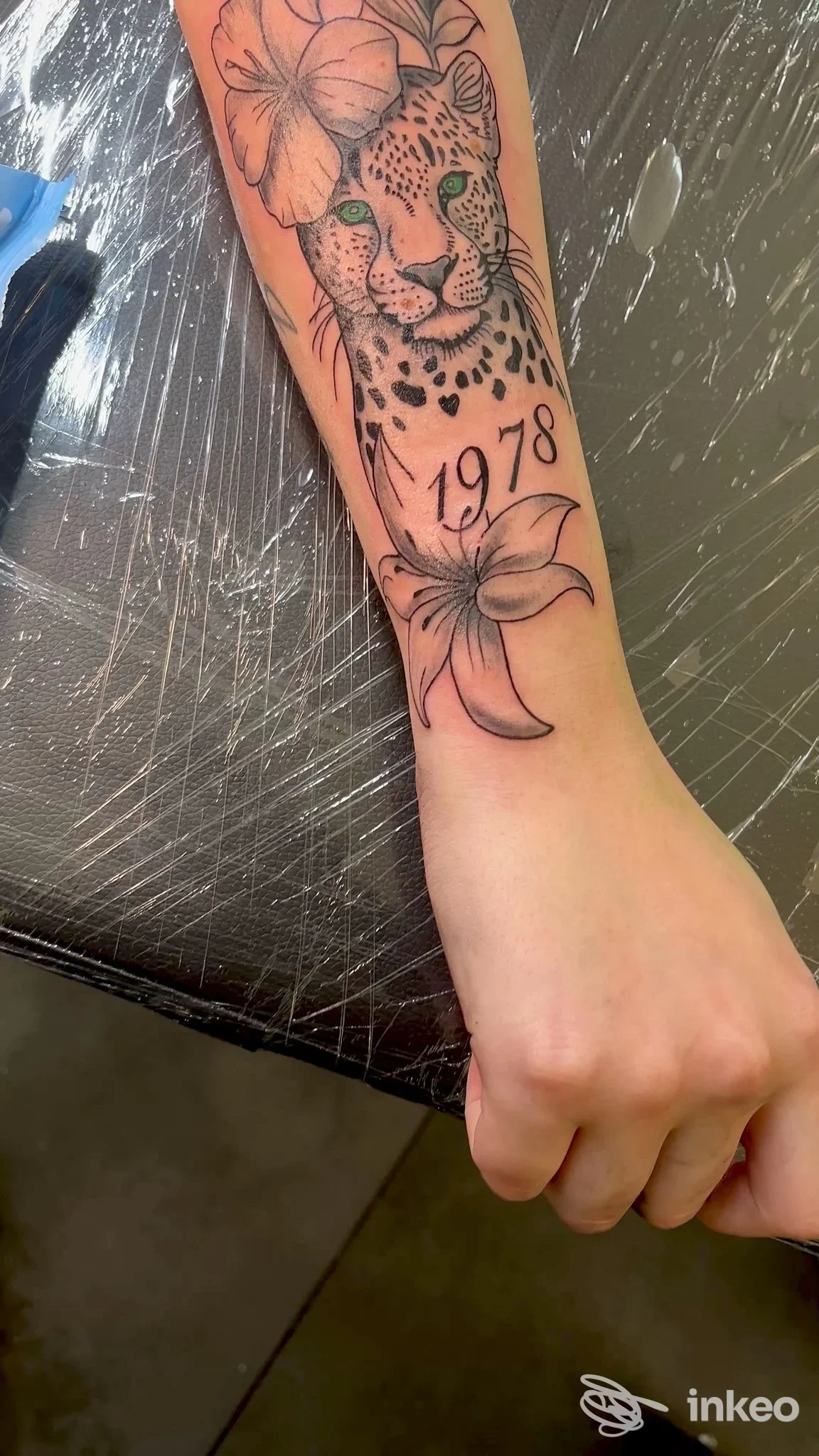 Avambraccio tatuato con testa di ghepardo e fiori, numero '1978'. Studio 55 Vicenza, Vicenza.