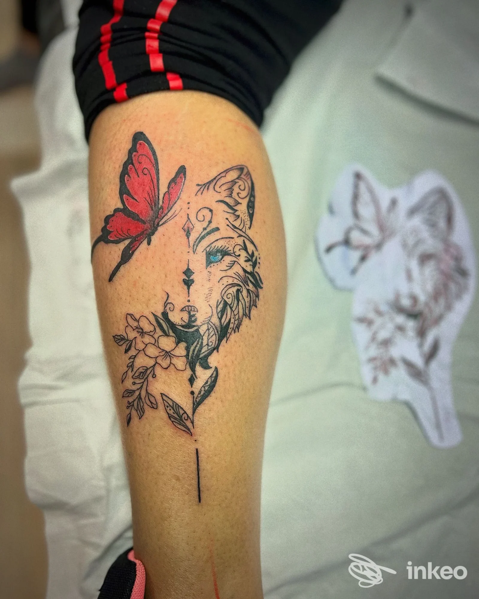 Avambraccio con tatuaggio di volpe stilizzata, farfalla rossa e fiori — immagine dal portfolio di Curu tattoo, Casazza.