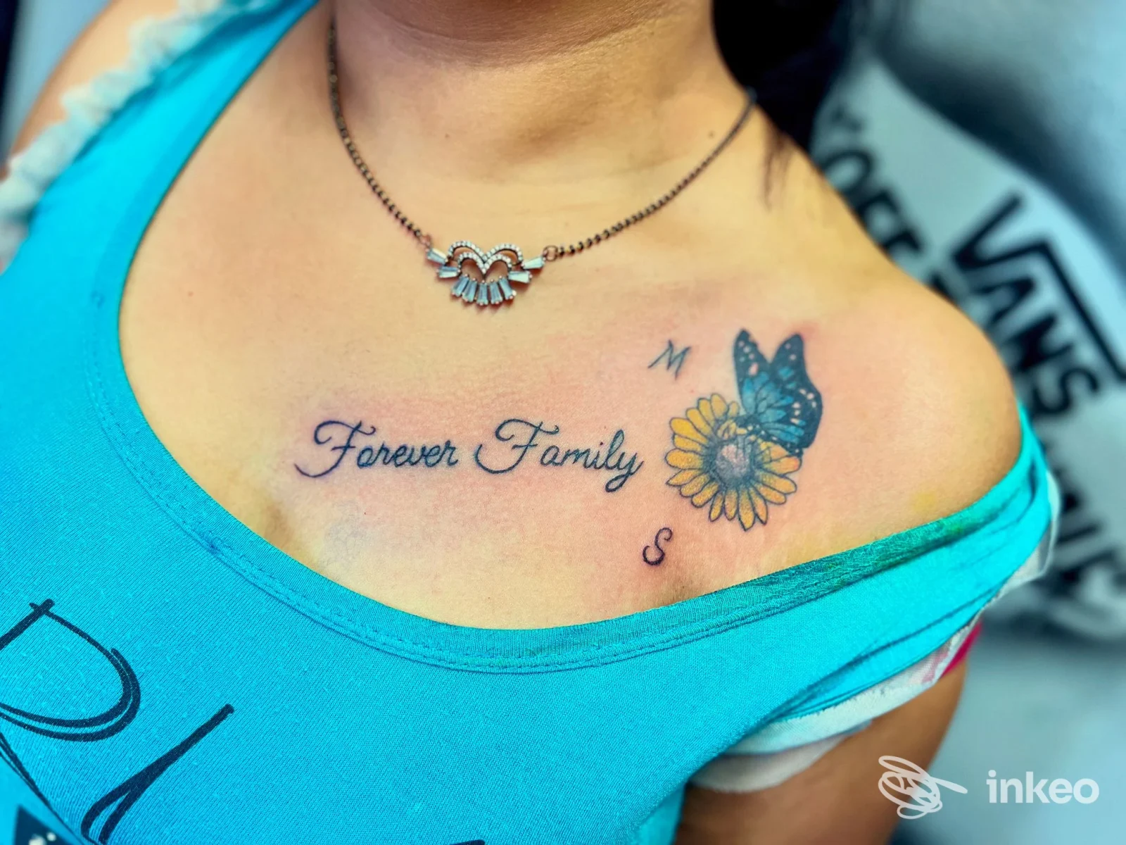Tatuaggio 'Forever Family' con fiore e farfalla sul pettorale, Curu tattoo, Casazza.