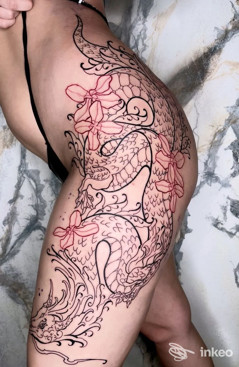 Ampio tatuaggio a contorno nero con fiori rossi su fianco, anca e coscia — The Biglia's Family, Santa Maria di Licodia.