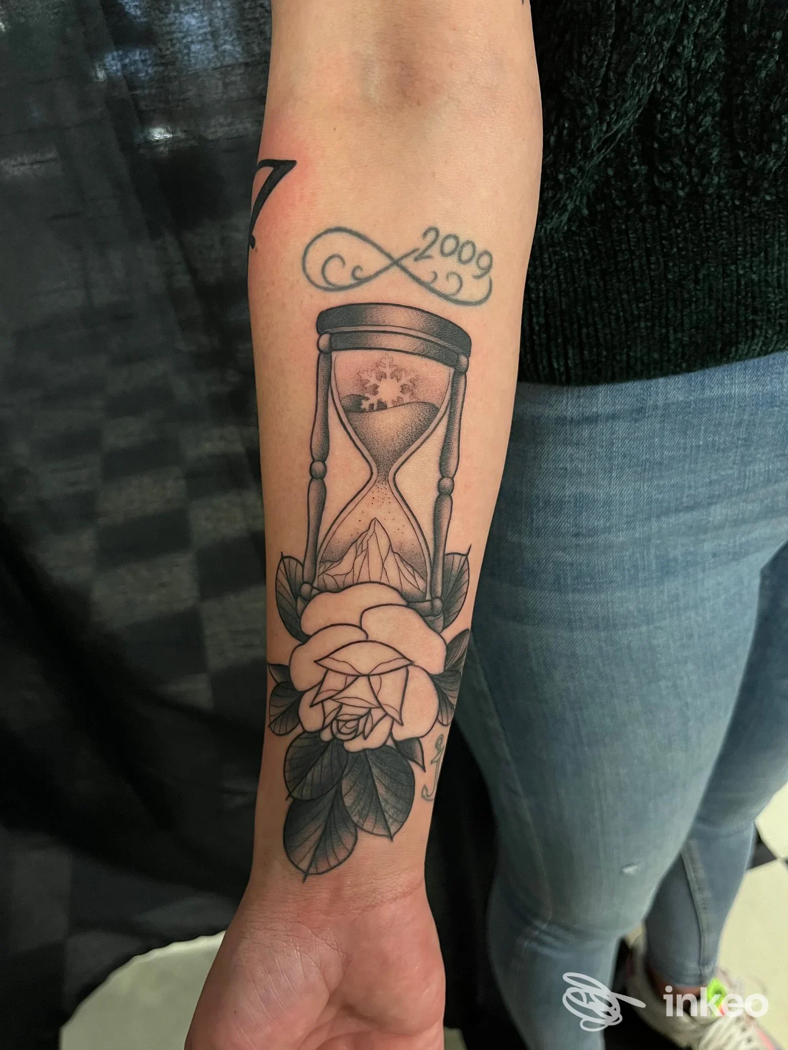 Tatuaggio sull'avambraccio con clessidra, paesaggio interno e rosa, foto da OTHERSIDE artigiano dell'inchiostro a Hône.