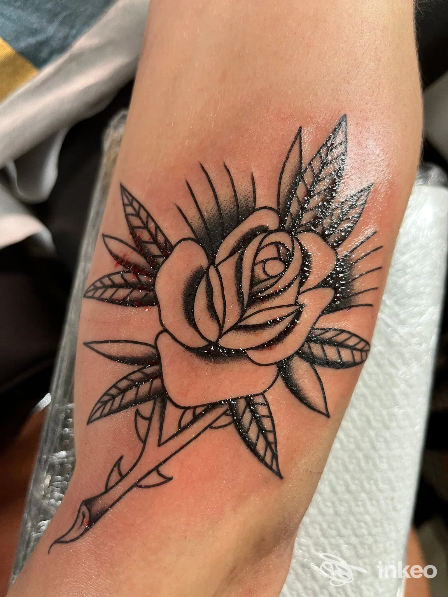 Tatuaggio a inchiostro nero di una rosa sull'avambraccio, foto fornita da OTHERSIDE artigiano dell'inchiostro a Hône.