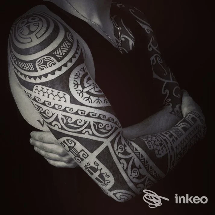 Foto di tatuaggi tribali su braccia e torace, studio Raniero Patutiki, Genova.