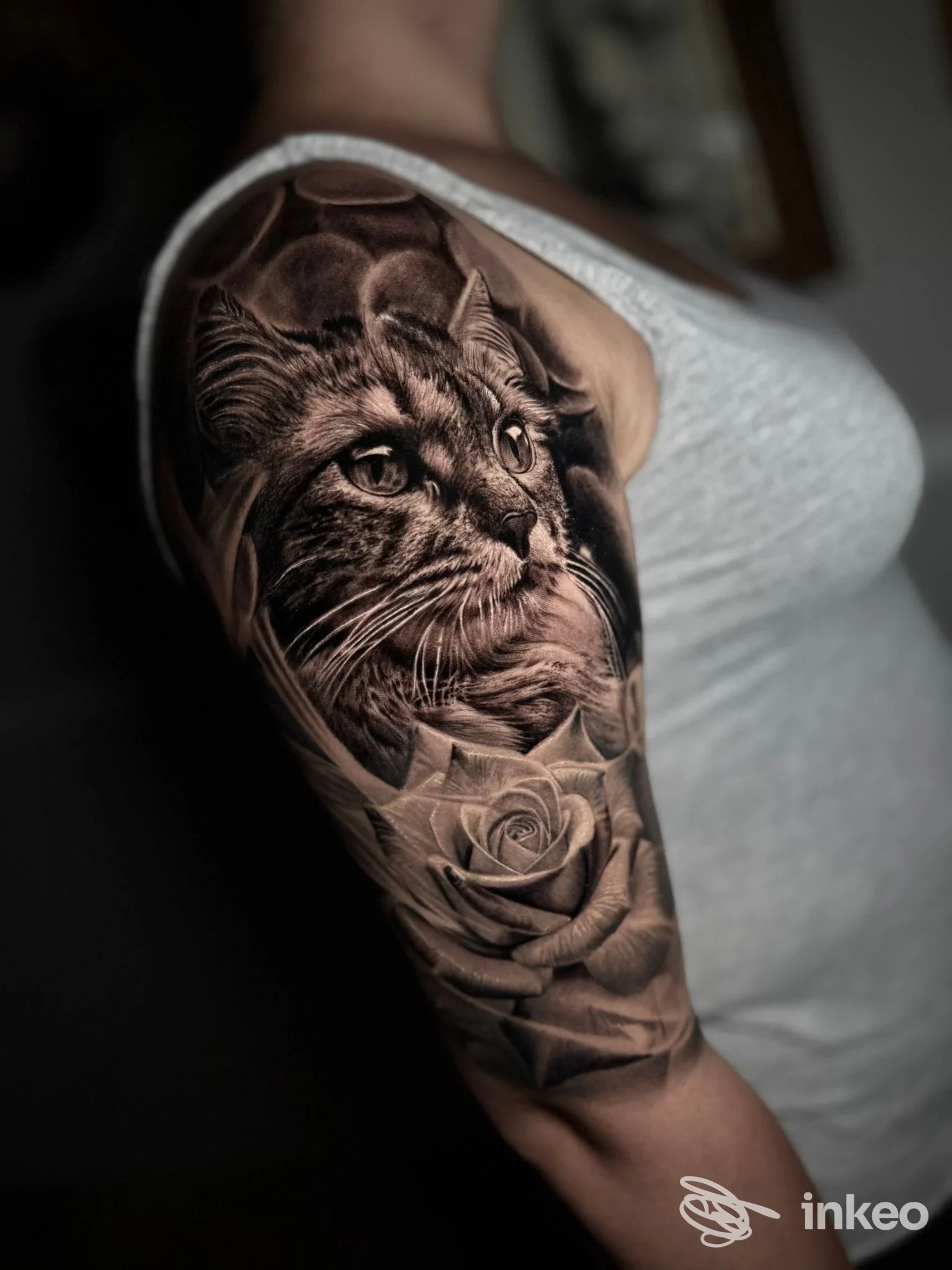 Tatuaggio realistico su braccio con volto di gatto e rosa, foto fornita dallo studio Santopietro a Montemesola.