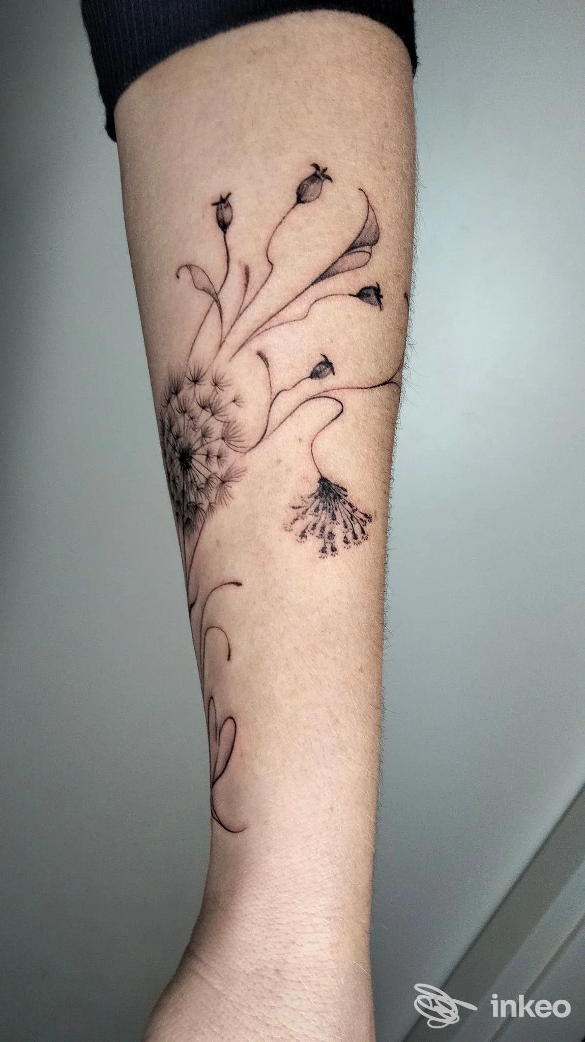 Tatuaggio a inchiostro nero di fiore stilizzato sull'avambraccio, Sacred Art, Varazze.