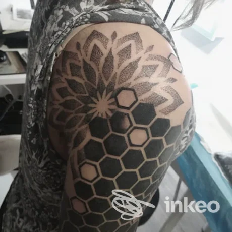 Tatuaggio geometrico a reticolo e dotwork sulla spalla e braccio superiore, foto dallo Studio Shell a Silea.