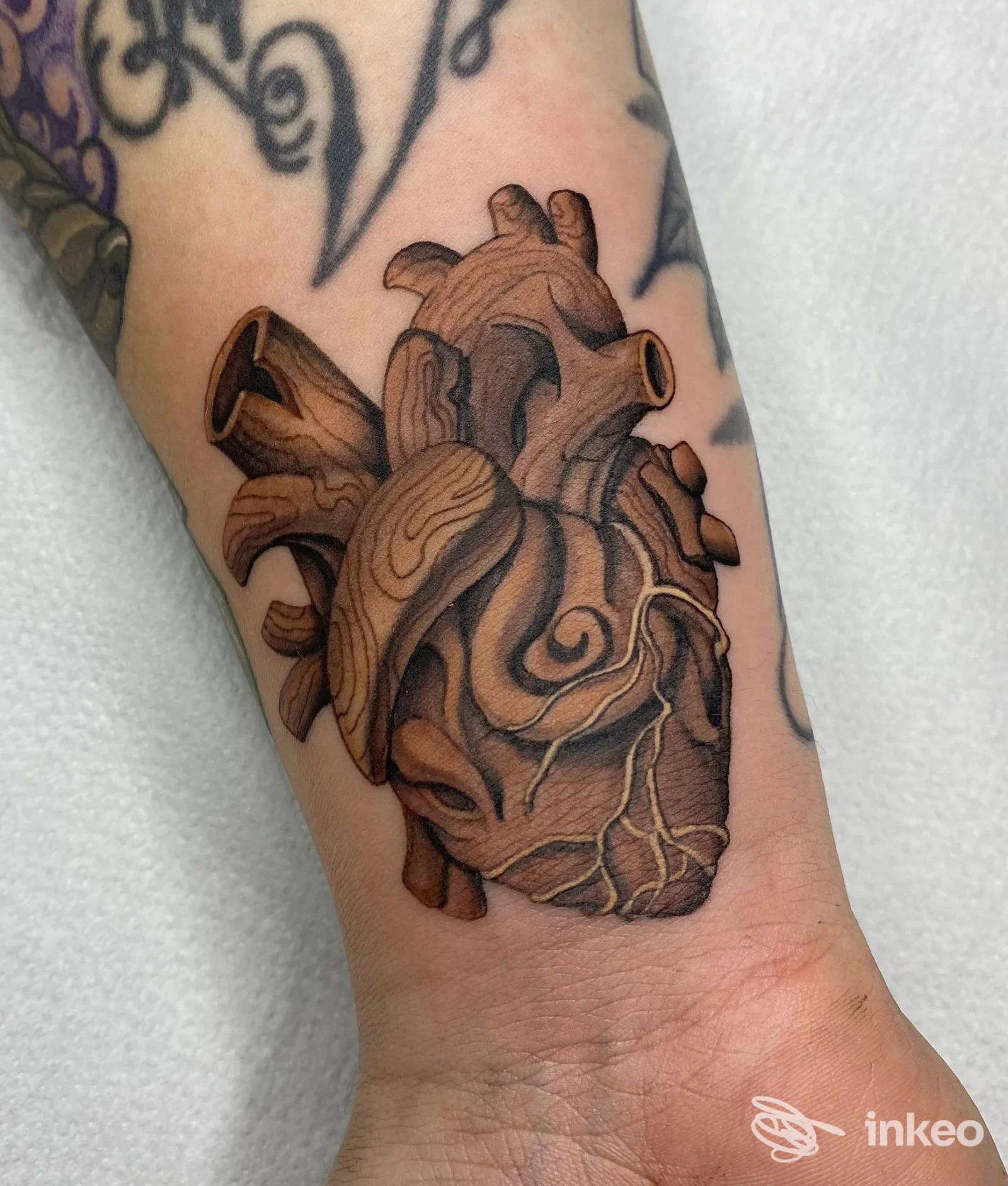 Tatuaggio a forma di cuore anatomico con effetto legno sull'avambraccio, foto portfolio di Mattia Draw Negro, Lecce.