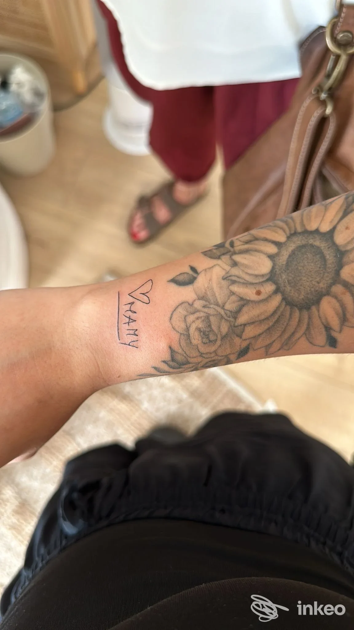 Primo piano di polso e avambraccio con tatuaggio floreale (girasole e rose), immagine fornita da Moonlight Tattoo Atelier a San Stino di Livenza.