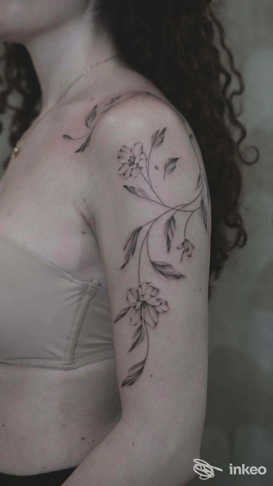 Tatuaggio floreale in nero/grigio sulla spalla e braccio superiore, scatto dal vivo — Moonlight Tattoo Atelier, San Stino di Livenza.