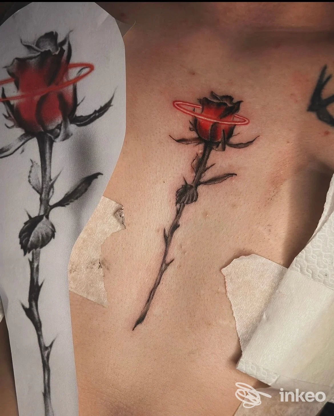 Tatuaggio a forma di rosa nera e rossa sul petto, con stencil cartaceo visibile; immagine fornita da Xenia Body Art, Badia Polesine.