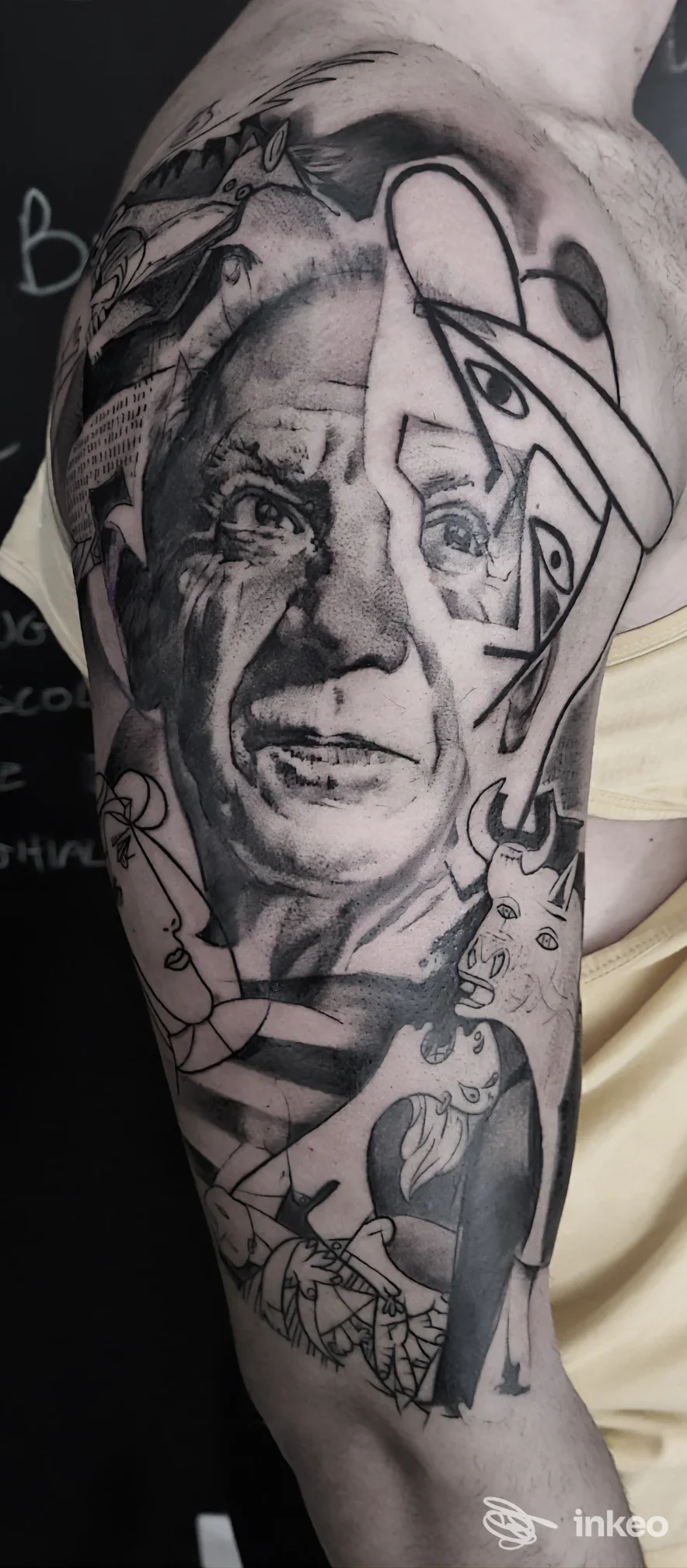 Foto di un tatuaggio a manica sul braccio realizzato da DUENDE a Ceccano, composizione figurativa e astratta in nero e grigio.