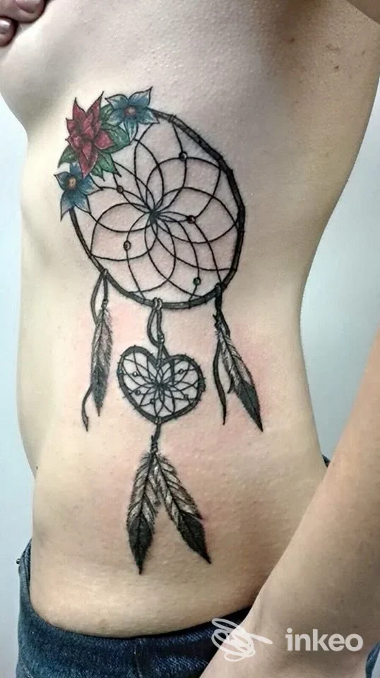 Tatuaggio acchiappasogni con fiori colorati sul fianco, eseguito da Skin Line, Pergine Valsugana.