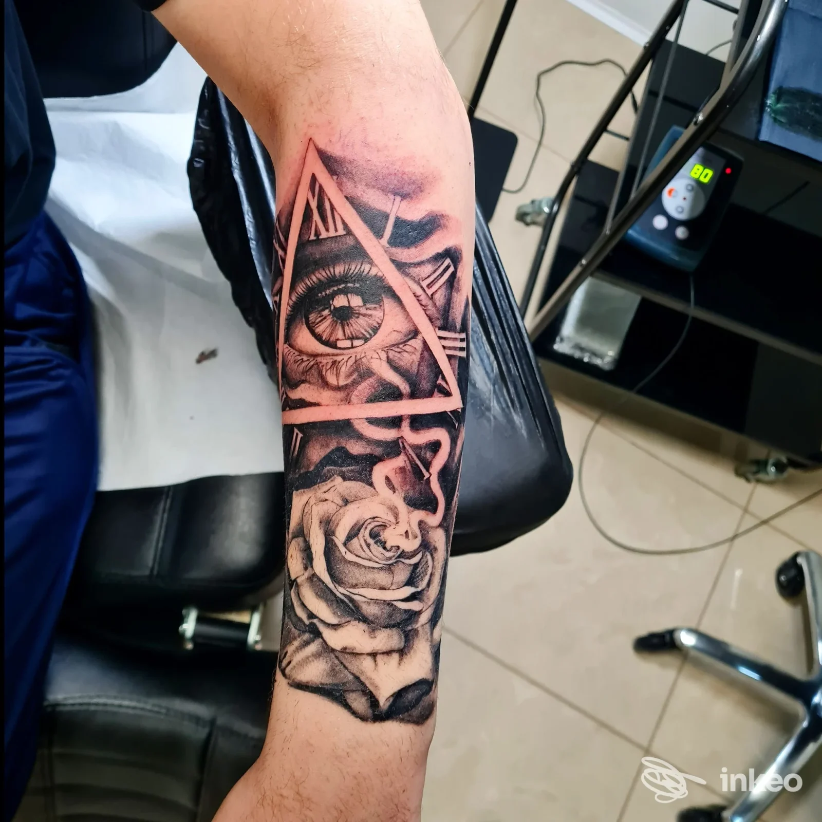 Tatuaggio black & grey su avambraccio con occhio in triangolo e rosa, Beauty and the Beast tattoo & nails, Lavello.